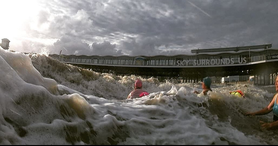 Sea swimmers wait for a wave to hit them